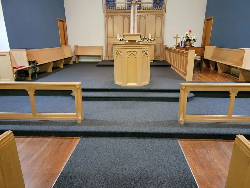 Church sanctuary with new blue carpeted steps and pews