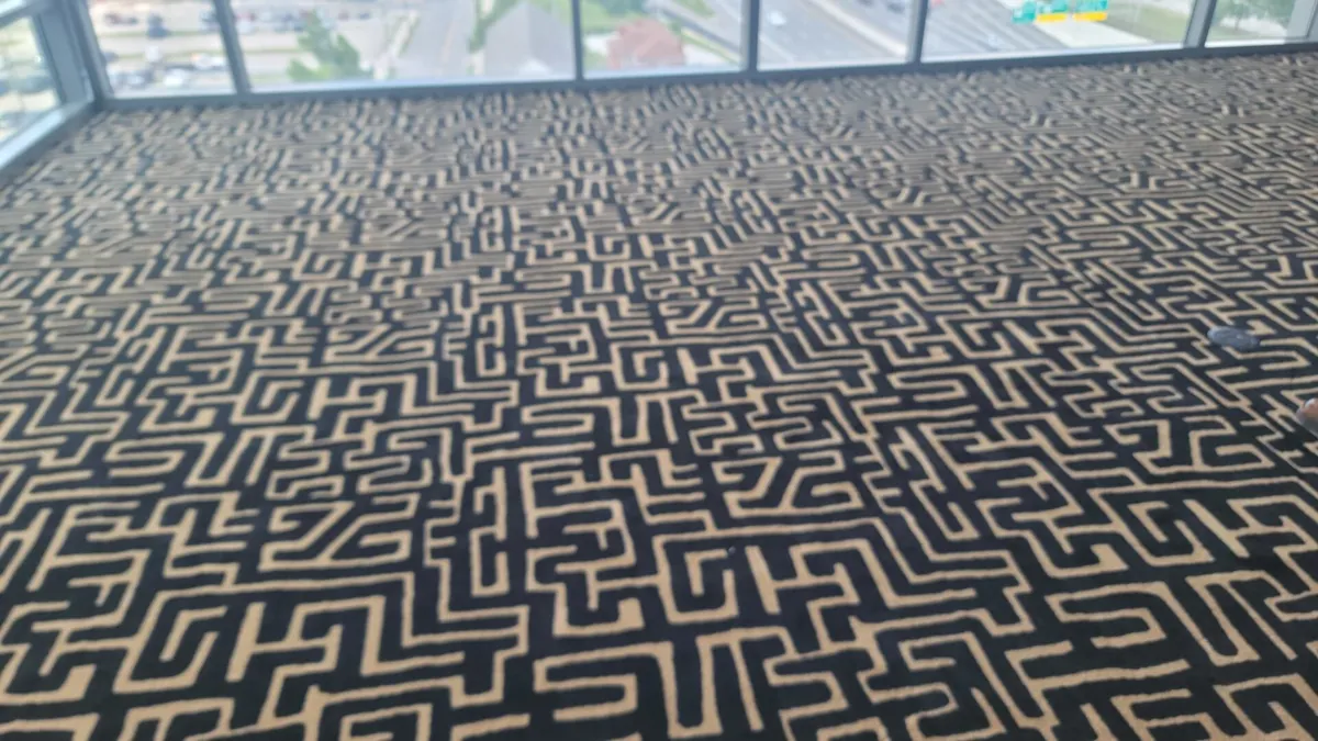 Black-and-gold geometric pattern carpet installed in a bright Grove City room