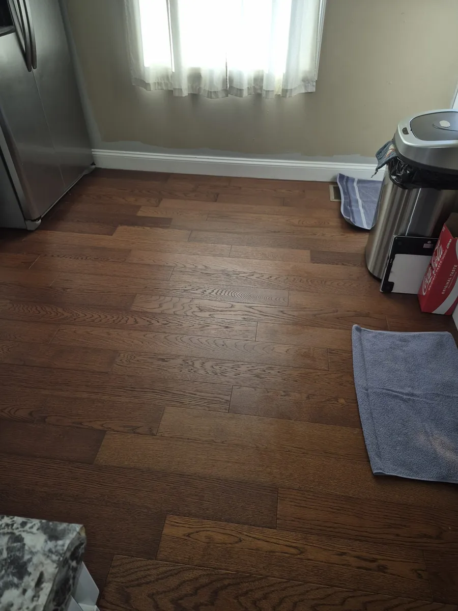 Finished wood floor in a small room with area rugs